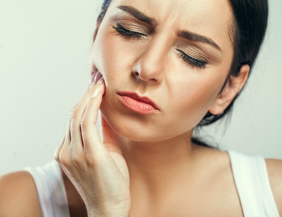 Woman with toothache seeks emergency dental care at a dentist in Malmö